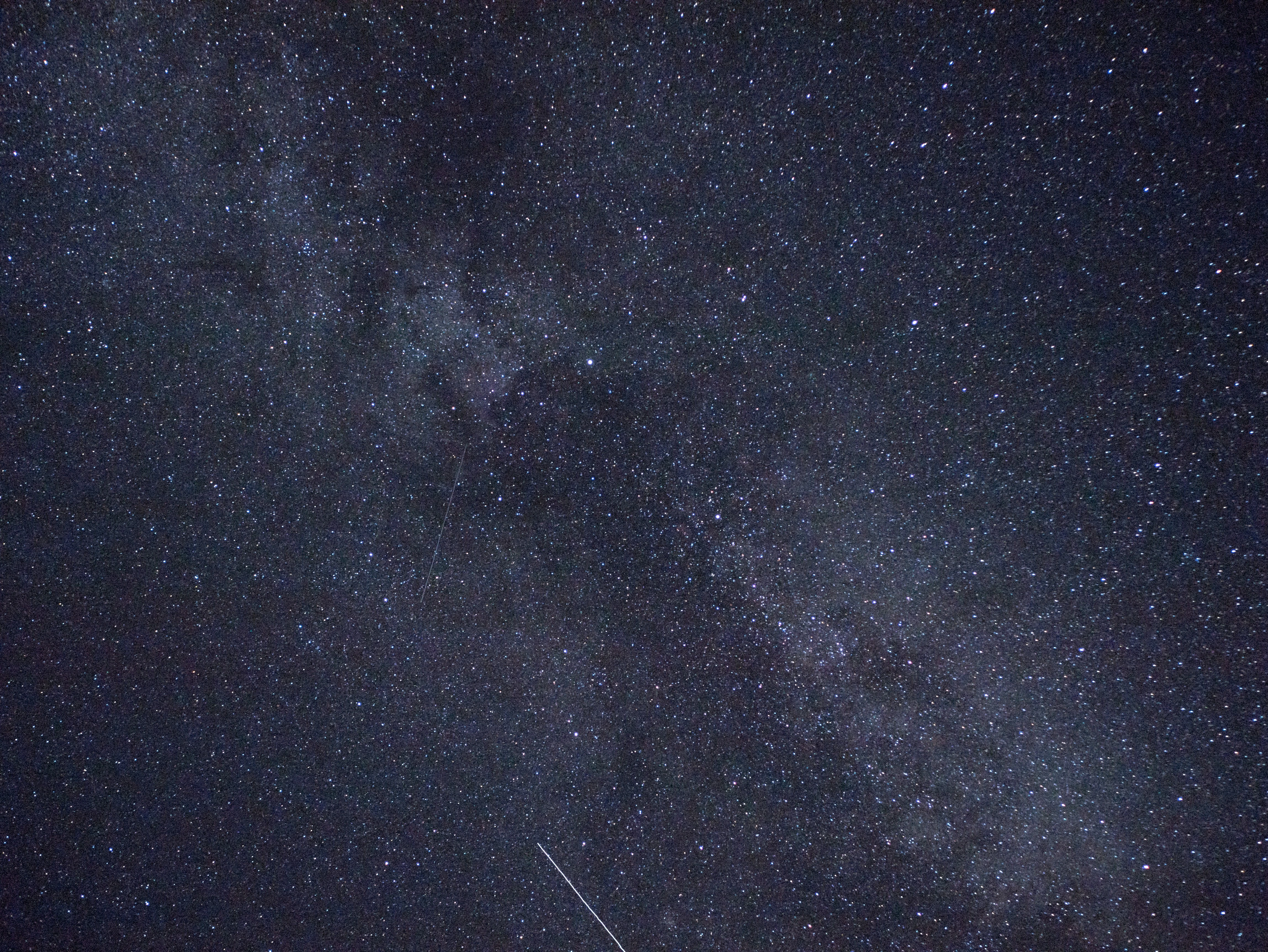 Droga Mleczna i jasny ślad meteoru z roju Perseidów na tle gwiezdnego nieba